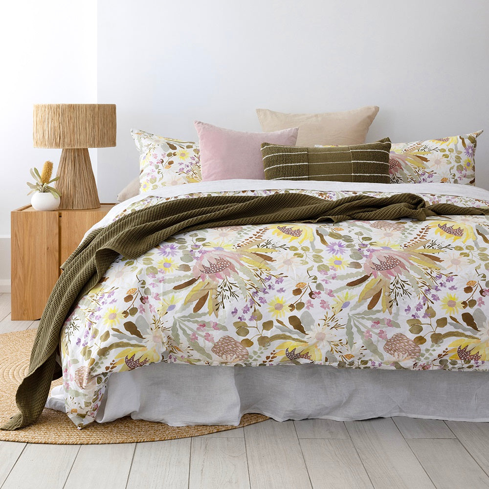 Bambury's Makea cotton quilt cover set in a Australian flora pattern with dark green throw blanket and decor cushions