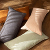 Bambury's Linen Rectangle Cushions in Charcoal, Sage, Hazel & Tea Rose, scattered on a wooden floor.